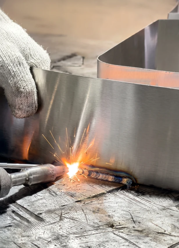 Welding a metal sign component